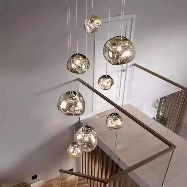 Lustre effet miroir moderne en boules de verre, idéal pour sublimer un escalier élégant et lumineux.