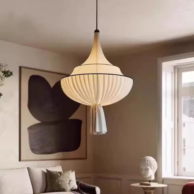 Suspension abat jour blanc en tissu plissé diffusant une lumière douce dans un salon lumineux et élégant.