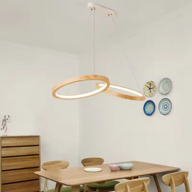 Suspension anneau bois au design épuré dans une salle à manger scandinave avec mobilier clair et décor mural en assiettes colorées.