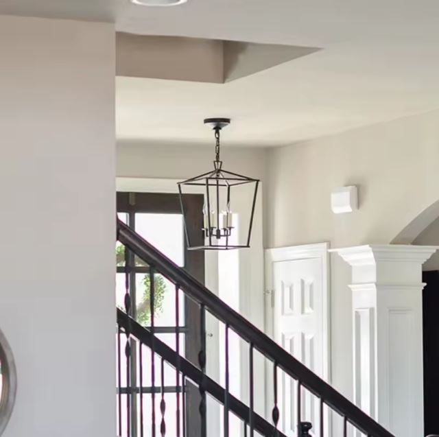 Suspension cage noire en métal installée dans une entrée avec escalier, apportant une touche élégante et structurée.