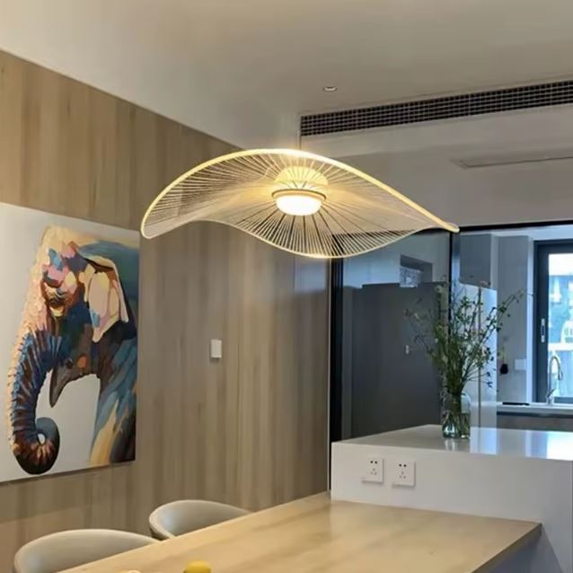 Suspension capeline blanche installée au-dessus d’un coin repas moderne, apportant une touche sculpturale et aérienne.