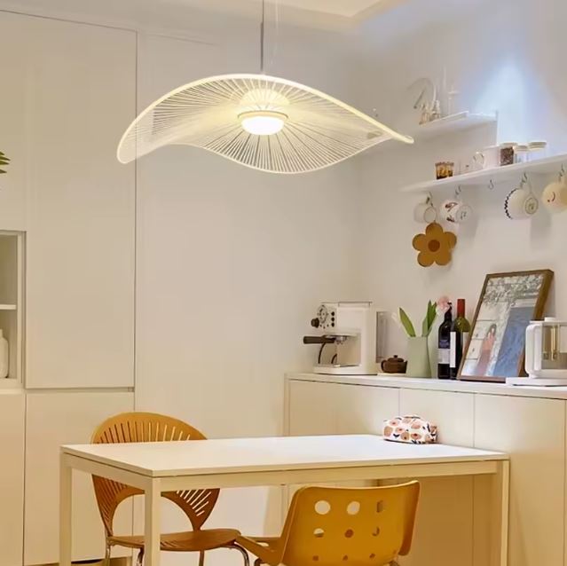 Suspension capeline blanche au design fluide, parfaite au-dessus d'une table à manger contemporaine et lumineuse.