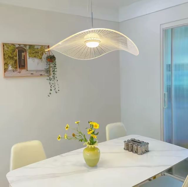 Suspension capeline blanche suspendue au-dessus d’une table à manger, parfaite pour une déco moderne et chaleureuse.