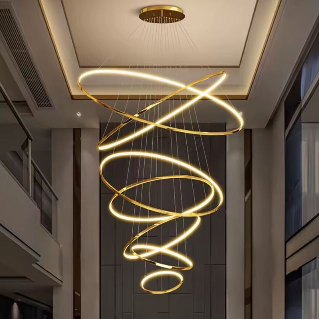 Suspension cascade grande hauteur en spirale dorée luxueuse, style art déco élégant pour vaste hall.