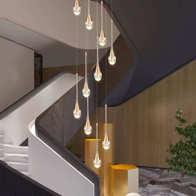 Suspension cristal doré en forme de goutte, idéale pour un escalier contemporain ou un hall d’entrée à l’esthétique chic et raffinée.