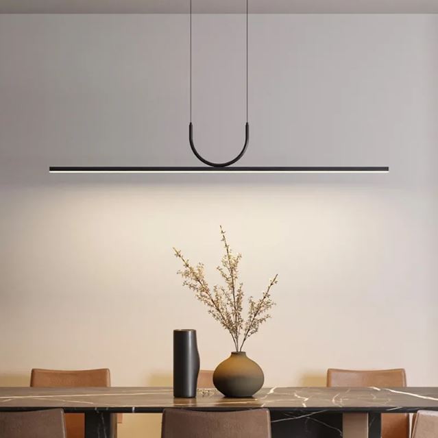 Suspension horizontale noire au-dessus d’une table à manger contemporaine, parfaite pour une ambiance raffinée et épurée.