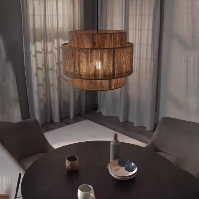Suspension en toile de jute au tissage fin diffusant une lumière chaude dans une salle à manger contemporaine.