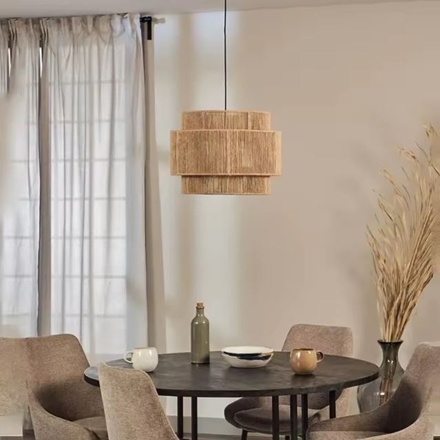 Suspension jute naturelle suspendue au-dessus d’une table ronde dans un salon scandinave épuré.