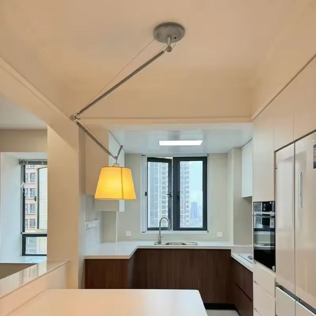 Suspension orientable avec bras articulé dans une cuisine moderne, parfaite pour ajuster l’éclairage selon les besoins du plan de travail.