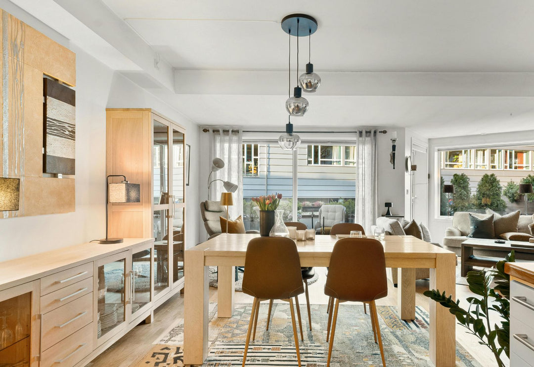 Lustre 3 suspensions en verre fumé au-dessus d’une table en bois, idéal pour rythmer une longueur sans alourdir l’espace.
