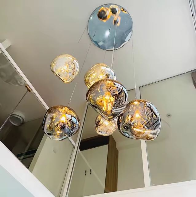 Lustre chromé à globes en verre effet miroir dans une cage d’escalier contemporaine, pour apporter éclat, profondeur et légèreté au volume.