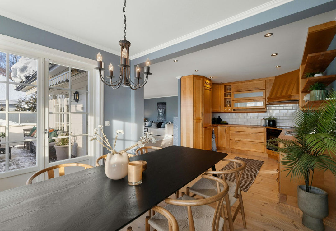 Lustre suspendu au-dessus d’une table dans une cuisine ouverte chaleureuse, pour structurer l’espace sans alourdir une pièce déjà décorée.