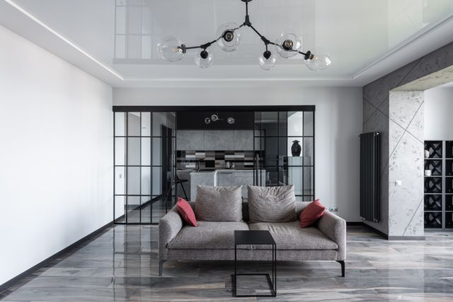 Salon moderne avec lustre à globes en verre transparent sur structure noire, apportant légèreté et volume sans alourdir la pièce.