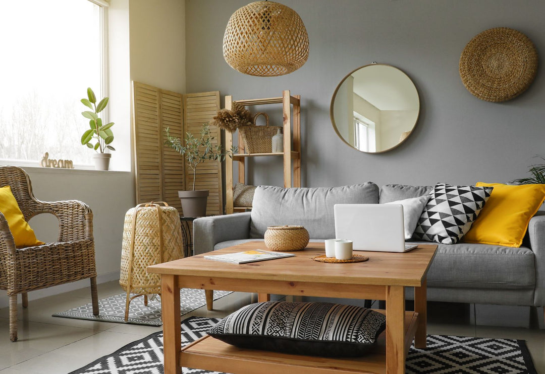 Salon chaleureux avec grande suspension en fibres tressées, mobilier en bois et matières naturelles dans une ambiance douce et texturée.