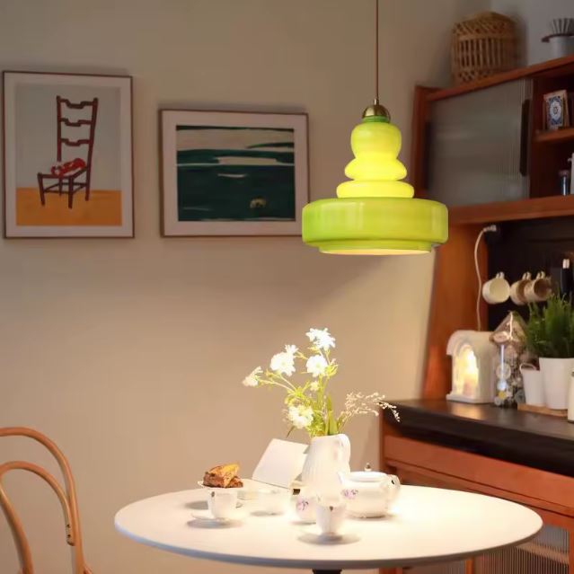 Suspension en verre vert au-dessus d'une table ronde : une touche colorée et design pour dynamiser la lumière sans alourdir la déco de la cuisine ou du salon.