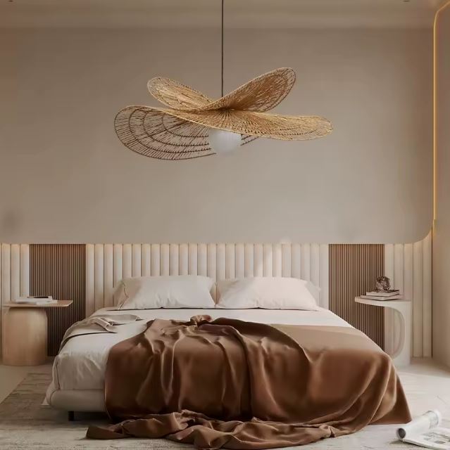 Suspension en rotin sculptural au-dessus d’un lit, idéale pour une chambre bohème, naturelle et apaisante à l’éclairage doux et enveloppant.