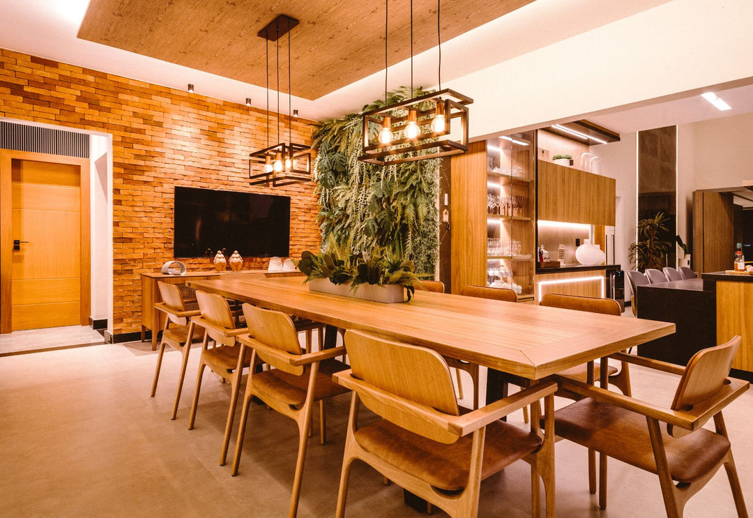 Deux suspensions au-dessus d’une grande table en bois structurent la salle à manger et créent une lumière chaleureuse, idéale pour les repas.
