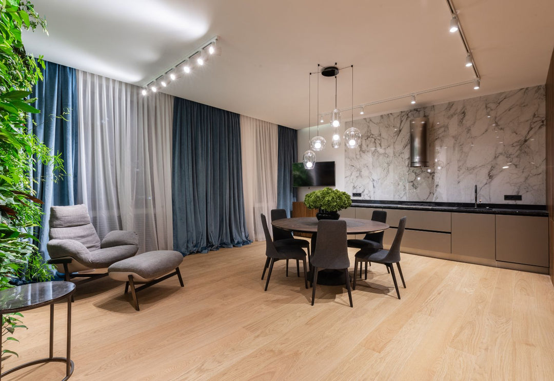 Suspension moderne dans un salon à grande hauteur, parfait pour structurer l’espace et révéler la verticalité de l'architecture intérieure.