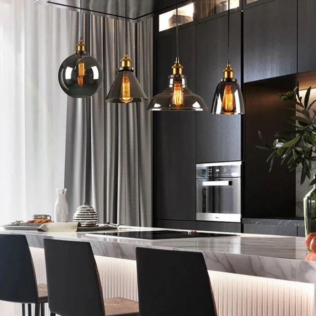 Suspensions en verre fumé d’inspiration vintage au-dessus d’un îlot, pour apporter profondeur, chaleur et caractère à une cuisine contemporaine.