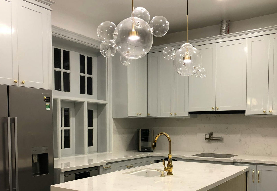 Suspensions en verre à globes dans une cuisine élégante : une lumière légère et raffinée qui structure l’espace sans l’alourdir.
