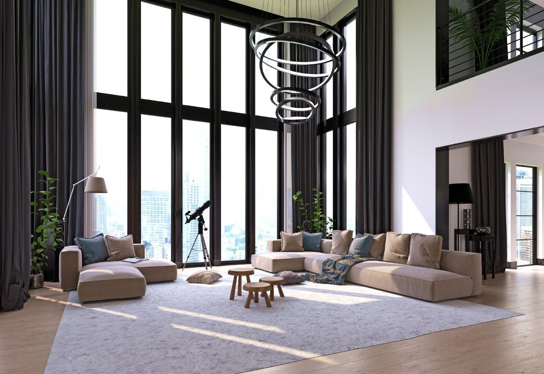 Luminaire vertical à anneaux lumineux structurant une entrée à grande hauteur sous plafond, pour sublimer le volume et guider le regard avec élégance.