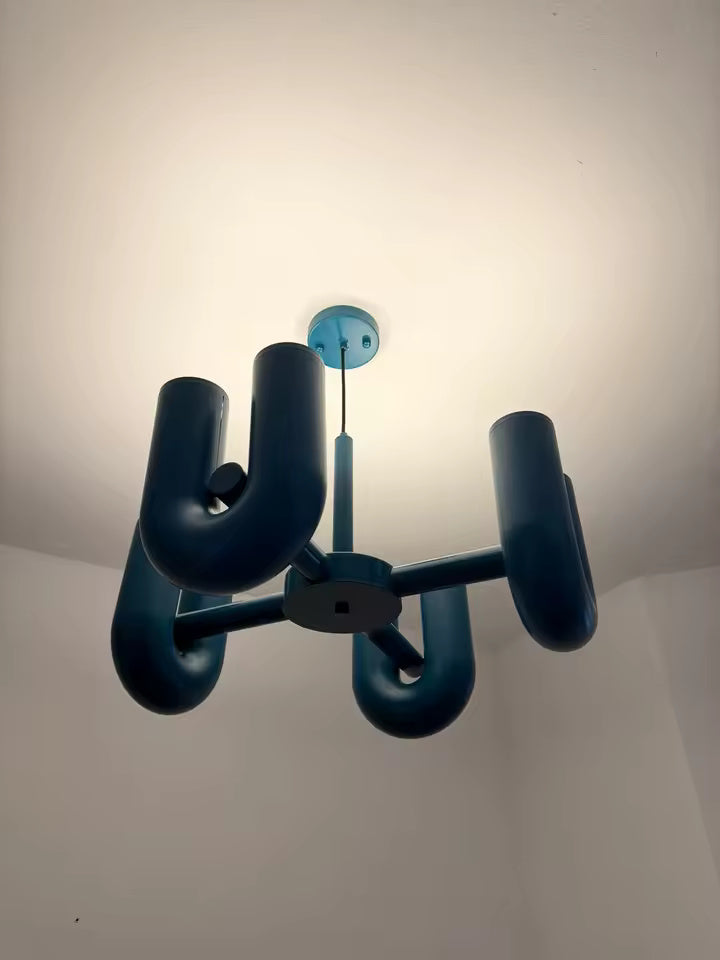 Vue de dessous de la suspension design tubulaire aux courbes en U en finition bleu allumée, mettant en valeur la répartition de l'éclairage LED et son design contemporain.