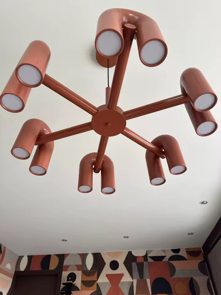 Vue supérieure de la suspension design tubulaire aux courbes en U en finition orange, mettant en valeur la disposition des tubes, la structure centrale et son design contemporain.