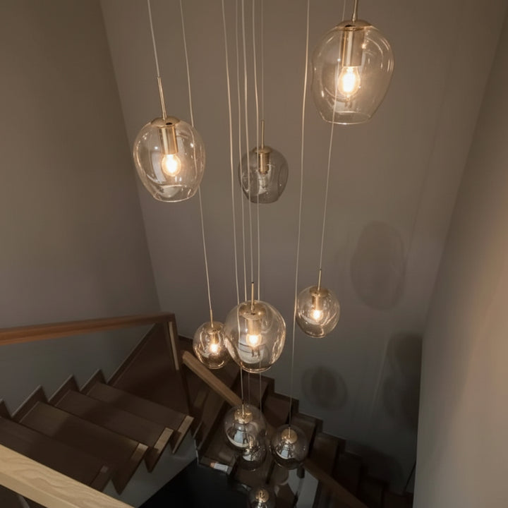 Suspension élégante composée de nombreuses boules en verre éclairées, idéale pour les entrées, halls et cages d'escalier modernes