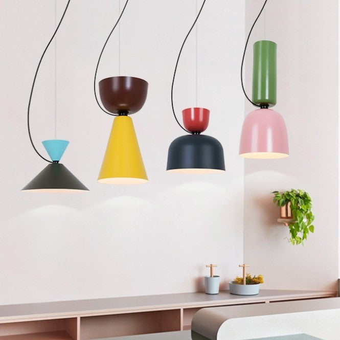 Ambiance feutrée créée par plusieurs suspensions colorées alignées au-dessus d'un long meuble en bois chaleureux.
