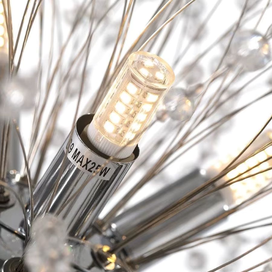 Gros plan sur une ampoule G9 LED intégrée à la structure rayonnante d’un lustre pissenlit chromé