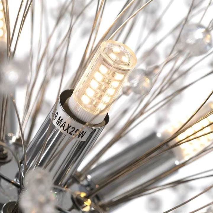 Gros plan sur une ampoule G9 LED intégrée à la structure rayonnante d’un lustre pissenlit chromé