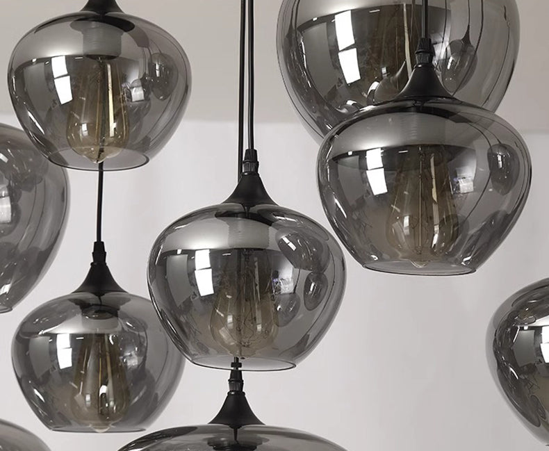 Vue rapprochée des ampoules à travers les sphères en verre fumé d'une suspension contemporaine.