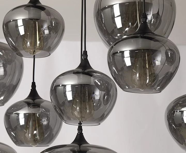 Vue rapprochée des ampoules à travers les sphères en verre fumé d'une suspension contemporaine.