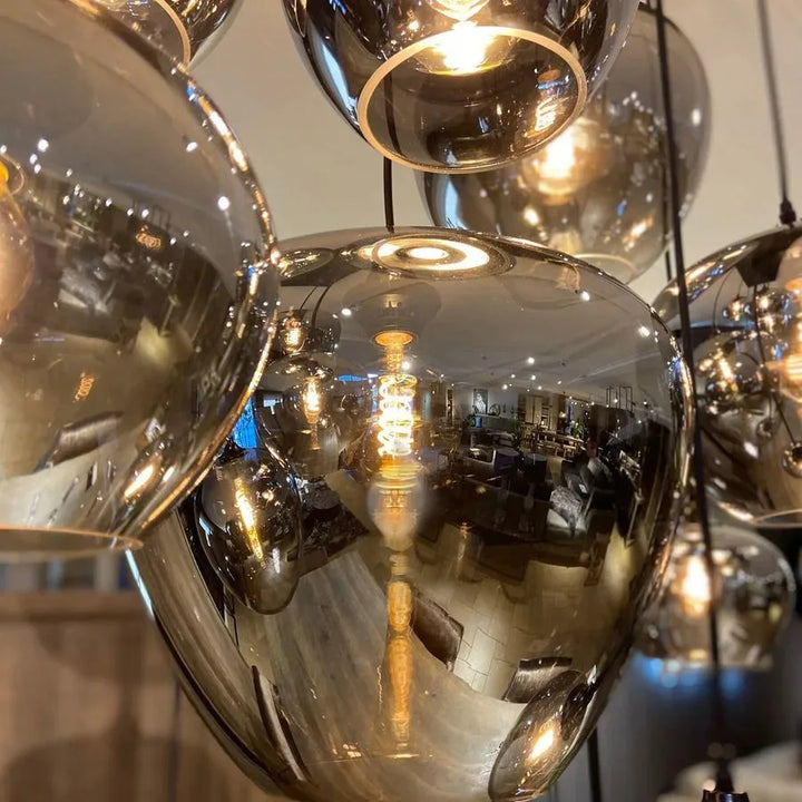 Détail rapproché d'un abat-jour en verre fumé d'une suspension contemporaine haut de gamme.
