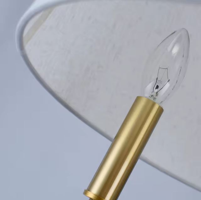 Détail de l’ampoule LED sur la suspension beige doré avec finitions en laiton.