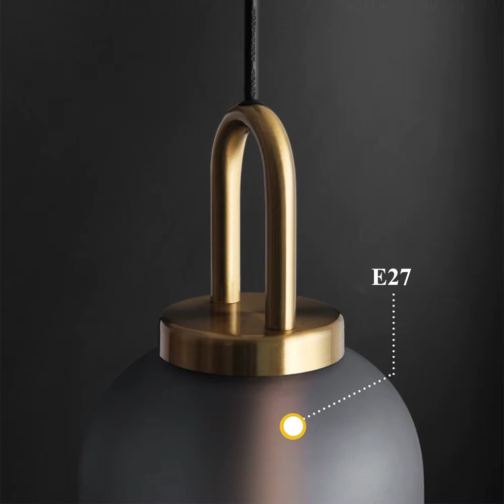 Détail de l’anse dorée et du culot E27 d’une suspension en verre fumé au style élégant et contemporain