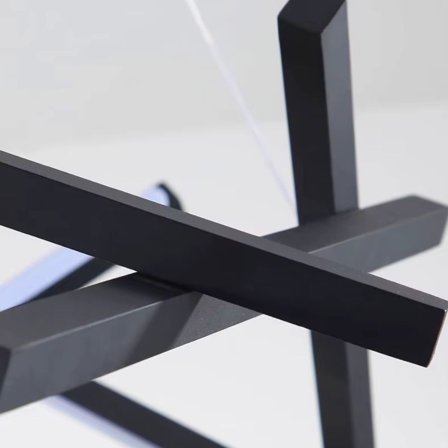 Gros plan sur les barres métalliques noires croisées  d'un lustre LED au design géométrique et contemporain.