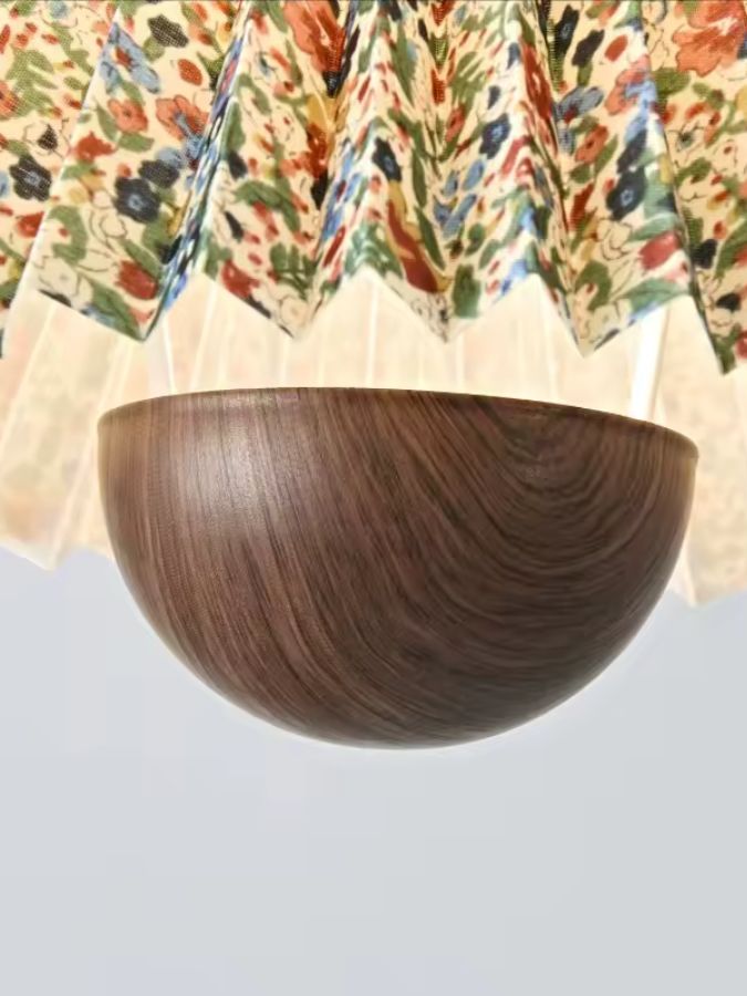 Gros plan sur la partie en bois brun sous l’abat-jour floral plissé, au style rétro chaleureux et décoratif