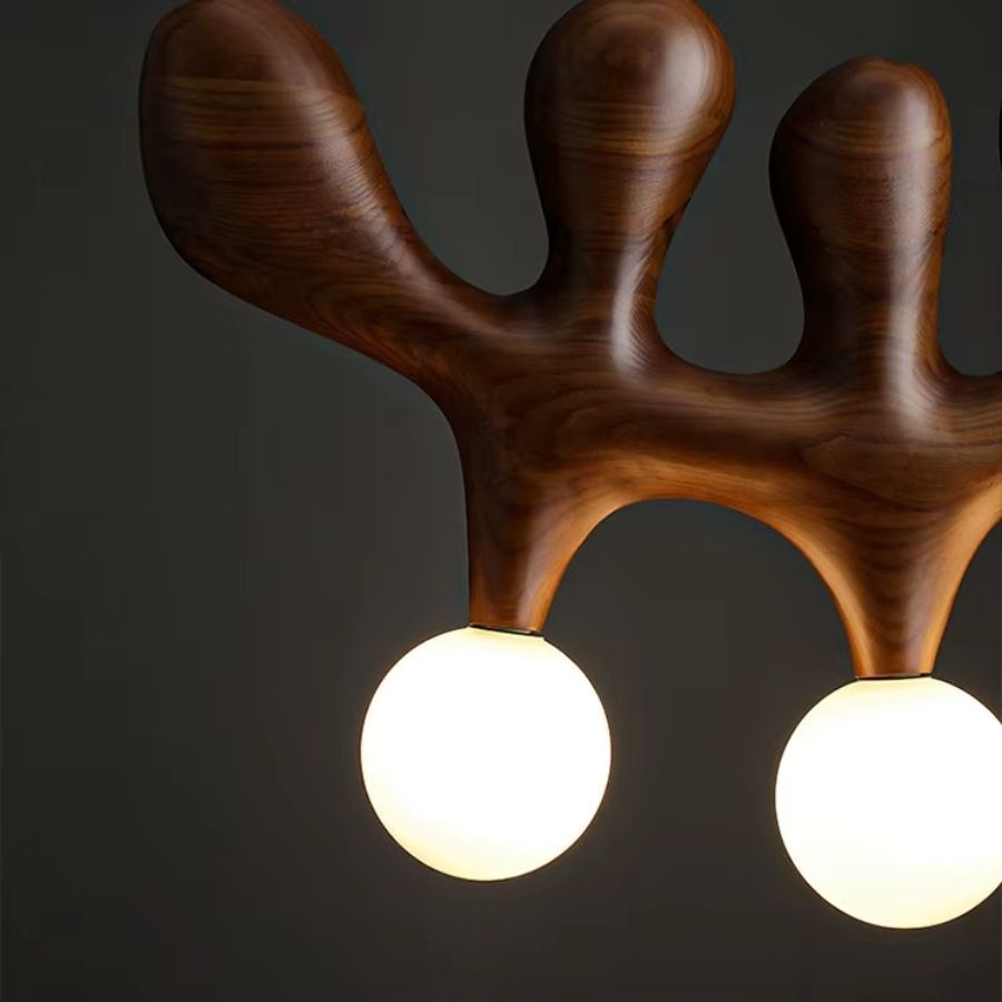 Finition bois foncé aux courbes organiques accompagnée de globes blancs lumineux sur ce lustre sculptural