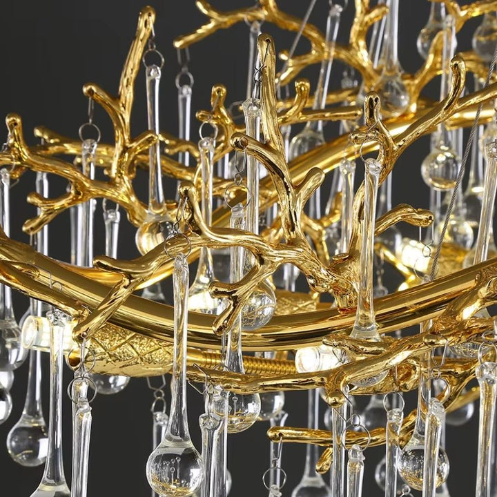 Branches dorées au relief organique et pampilles de cristal composent le décor sculptural et précieux de ce lustre