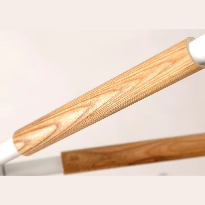 Gros plan sur un bras en bois clair du lustre scandinave, mettant en valeur sa finition naturelle et chaleureuse