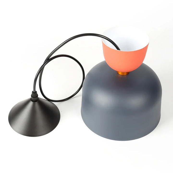 Détail du câble et de l'abat-jour d'une suspension ronde en métal gris et détail orange au design artistique affirmé.