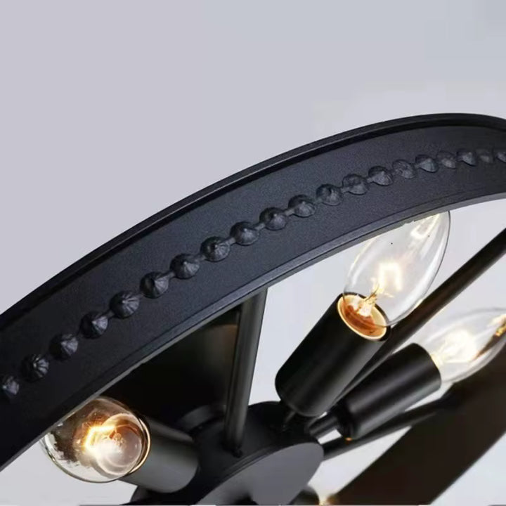 Gros plan sur le cerclage noir et les ampoules du lustre roue, avec détails métalliques au style industriel vintage