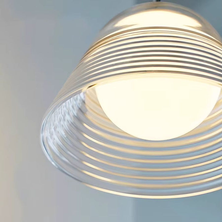 Vue sous la cloche en verre soufflé strié, révélant le globe opalin et une lumière douce au charme rétro