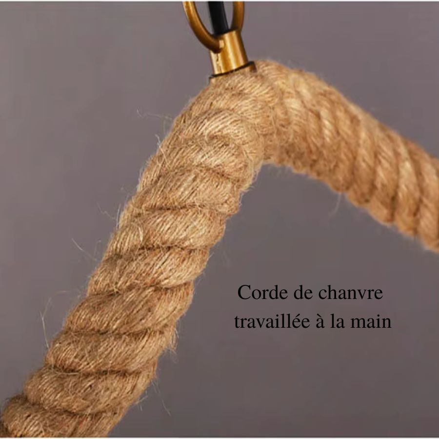 Gros plan sur la corde de chanvre épaisse enroulée autour du bras courbé d'un lustre naturel au style rustique.