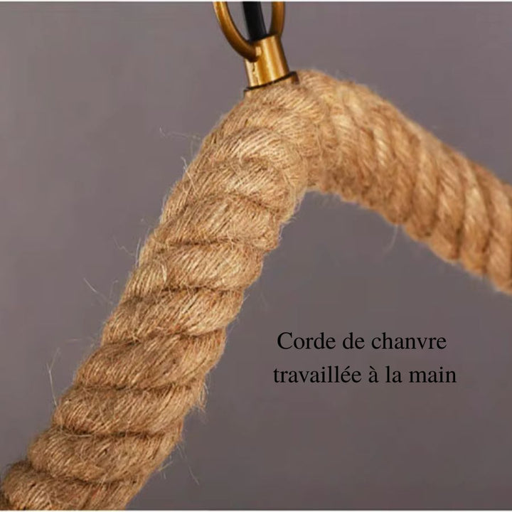 Gros plan sur la corde de chanvre épaisse enroulée autour du bras courbé d'un lustre naturel au style rustique.