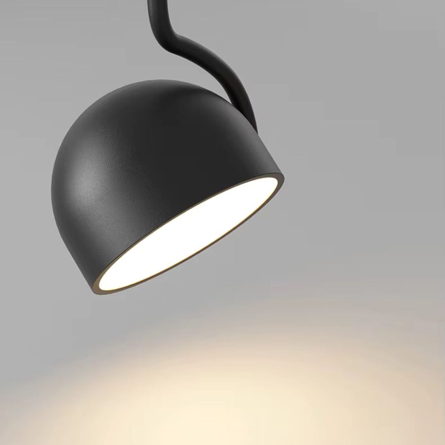 Gros plan sur la coupole noire d’une suspension orientable au design minimaliste avec éclairage directionnel