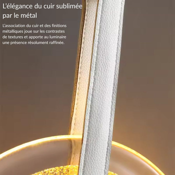 Détail de la lanière en cuir et des finitions métalliques d’une suspension médaillon en verre au style raffiné