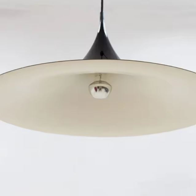 Vue de dessous d’une suspension noire en large disque, au charme bauhaus et vintage années 50.