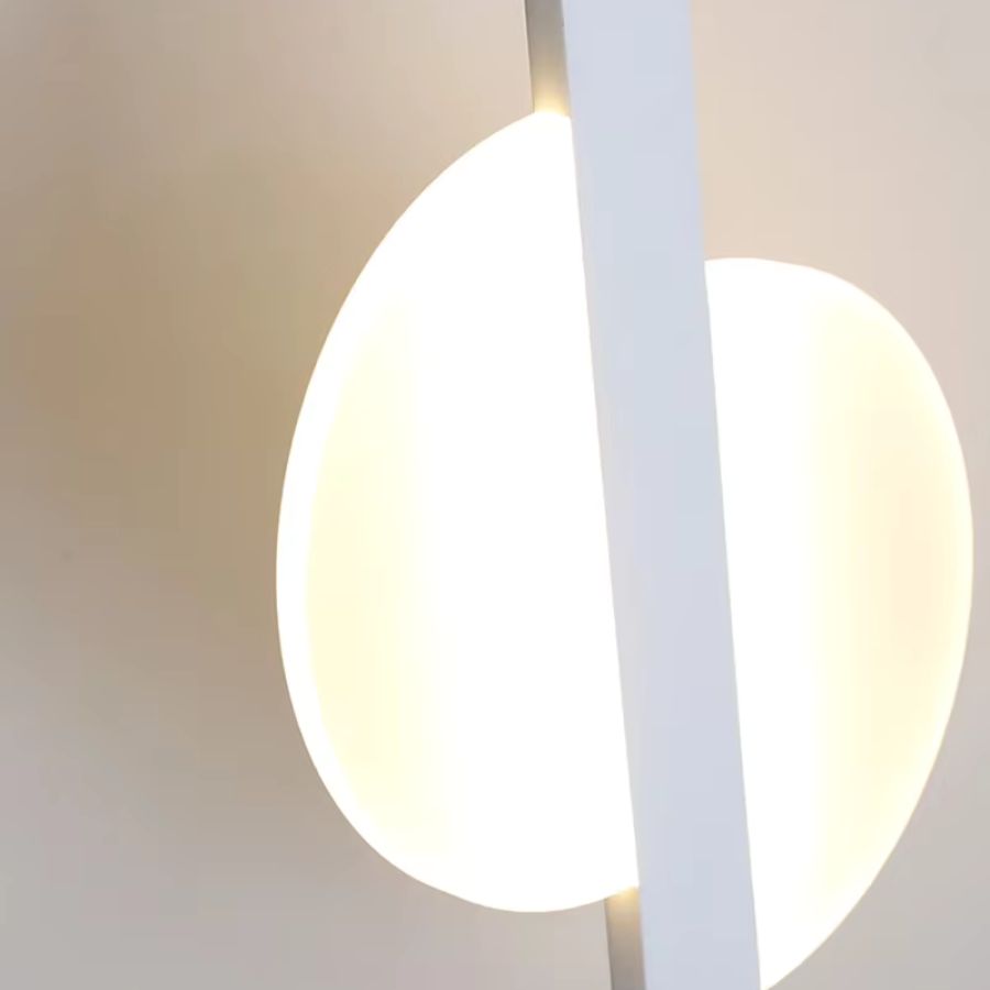 Détail du disque lumineux blanc d’une suspension à bande verticale au style minimaliste et futuriste